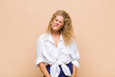 Orta yaşlı bir kadın, hangi seçeneği seçeceğine karar veremediğini ve sorunu çözmeye çalıştığını düşünüyor.