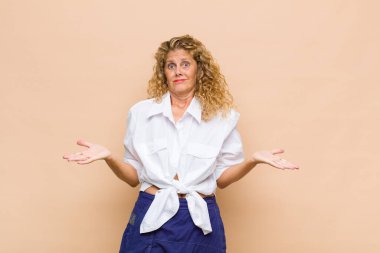 Orta yaşlı kadın şaşkın ve kafası karışmış hissediyor, doğru cevap ya da karardan emin değil, bir seçim yapmaya çalışıyor.