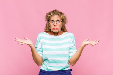 Orta yaşlı kadın şaşkın ve şaşkın hissediyor, şüpheci, farklı seçenekleri tartıyor veya komik bir ifadeyle seçiyor.