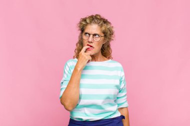 Şaşırmış, gergin, endişeli ya da korkmuş bakışları olan orta yaşlı bir kadın fotokopi alanına doğru bakıyor.