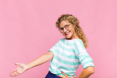 Orta yaşlı bir kadın kendini mutlu ve neşeli hissediyor, gülümsüyor ve seni hoş karşılıyor, dostça bir jestle içeri davet ediyor.