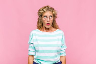 Orta yaşlı kadın endişeli, stresli, endişeli ve korkmuş, panikleyen ve dişlerini sıkan görünüyor.