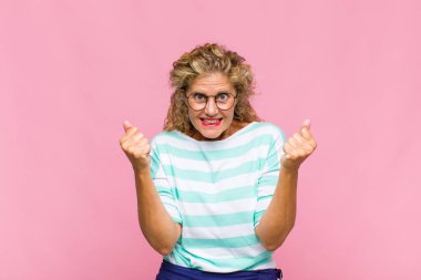 Orta yaşlı kadın şaşkın, heyecanlı ve mutlu hissediyor, gülüyor ve başarıyı kutluyor,!