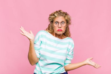 Orta yaşlı kadın şaşkın, kafası karışmış ve stresli görünüyor, farklı seçenekler arasında merak ediyor, kararsız hissediyor.