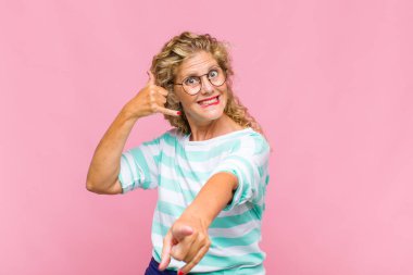 Orta yaşlı bir kadın neşeli bir şekilde gülümsüyor ve kamerayı işaret ediyor. Sonra seni arıyor, telefonla konuşuyor.