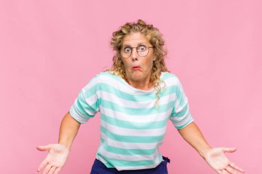 Middle age woman feeling clueless and confused, having no idea, absolutely puzzled with a dumb or foolish look