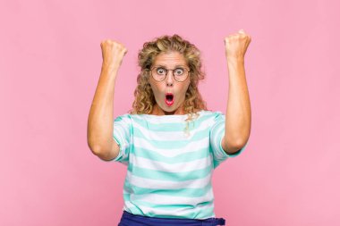 Orta yaşlı bir kadın inanılmaz bir başarıyı kutluyor. Kazanan gibi, heyecanlı ve mutlu görünüyor.!