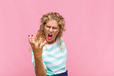 Orta yaşlı bir kadın sinirli, sinirli ve sinirli görünüyor. Senin neyin var? 