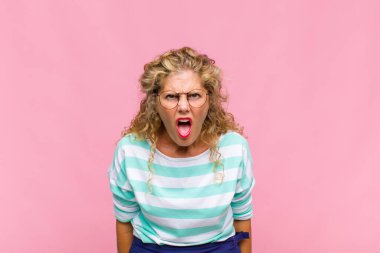 Orta yaşlı bir kadın şok olmuş, kızgın, sinirli ya da hayal kırıklığına uğramış, ağzı açık ve öfkeli görünüyor.