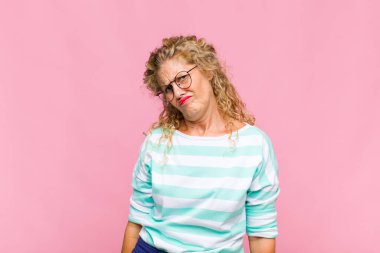 Orta yaşlı bir kadın üzgün ve mızmızlanıyor, mutsuz bir bakışla, negatif ve hayal kırıklığına uğramış bir tavırla ağlıyor.