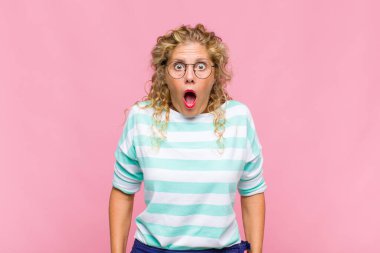 Orta yaşlı kadın korkmuş ve şok olmuş hissediyor, ağzı açık şaşkınlık içinde.