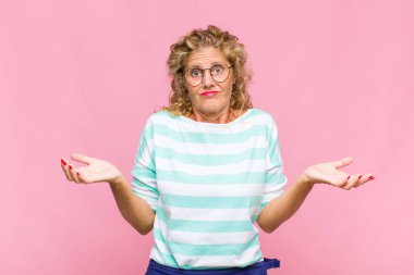 Orta yaşlı bir kadın bilgisiz ve kafası karışık, hangi seçeneği seçeceğinden emin değil, merak ediyor.