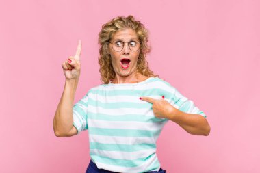 Orta yaşlı bir kadın gururlu ve şaşırmış, kendine güvenen, kendini bir numara gibi hisseden.