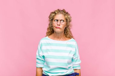 Orta yaşlı bir kadın aptal ve komik görünüyor. Şaşı bakışlı, şakacı ve şakacı.