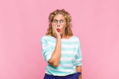 Orta yaşlı bir kadın ağzı açık bir şekilde yüz yüze inanmayarak şok olmuş ve hayrete düşmüş hissediyor.