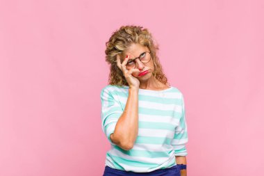 Orta yaşlı bir kadın yorgun, sıkıcı ve sıkıcı bir işten sonra sıkılmış, hayal kırıklığına uğramış ve uykulu hisseder.