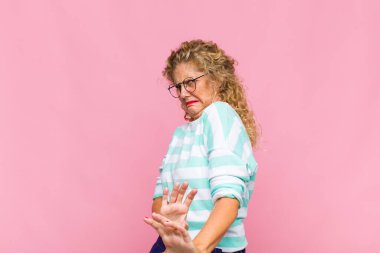 Orta yaşlı bir kadın tiksinmiş ve midesi bulanıyor. İğrenç, kokuşmuş ya da kokuşmuş bir şeyden kaçıyor.