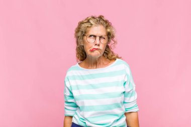 Orta yaşlı bir kadın, hangi seçeneği seçeceğine karar veremediğini ve sorunu çözmeye çalıştığını düşünüyor.