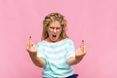 Orta yaşlı kadın kışkırtıcı, agresif ve müstehcen hissediyor. İsyankar bir tavırla orta parmağını hareket ettiriyor.