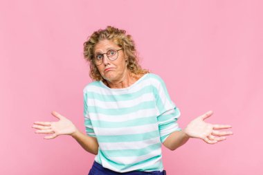 Orta yaşlı kadın şaşkın ve kafası karışmış hissediyor, doğru cevap ya da karardan emin değil, bir seçim yapmaya çalışıyor.