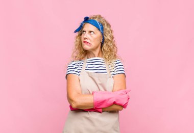 Orta yaşlı bir kadın şüphe ediyor ya da düşünüyor, dudağını ısırıyor ve kendini güvensiz ve gergin hissediyor. Yan hizmetçi konseptinde yer arıyor.