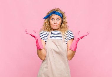 Orta yaşlı kadın şaşkın ve şaşkın hissediyor, şüpheci, farklı seçenekleri tartıyor ya da seçiyor.