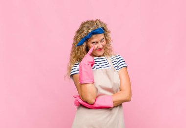 Orta yaşlı bir kadın sana göz kulak oluyor, güvenmiyor, izliyor ve tetikte ve tetikte bekliyor.