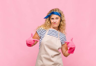 Orta yaşlı bir kadın gururlu, kibirli, mutlu, şaşırmış ve tatmin olmuş görünüyor, kendini gösteriyor, kazanan bir hizmetçi gibi hissediyor.