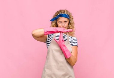 Orta yaşlı bir kadın ciddi, sert, kızgın ve hoşnutsuz görünüyor.