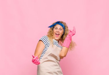 Orta yaşlı kadın gülümsüyor, kaygısız, rahat ve mutlu hissediyor, dans ediyor ve müzik dinliyor, parti kahyası konseptinde eğleniyor.