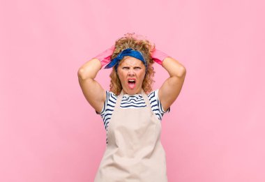 Orta yaşlı bir kadın stresli, endişeli, endişeli ya da korkmuş, elleri başının üstünde, hata yapan hizmetçi konseptiyle panikliyor.