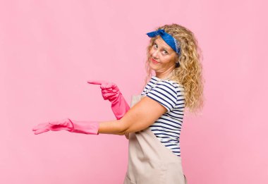 Orta yaşlı kadın gülümsüyor, mutlu, kaygısız ve tatmin olmuş hissediyor. Yan kapıdaki fotokopi alanı kavramına veya fikrine işaret ediyor.