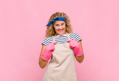 Orta yaşlı bir kadın mutlu, şaşkın ve gururlu hissediyor. Heyecanlı, şaşkın bakışlı ev kadını konseptiyle kendini gösteriyor.