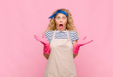 Orta yaşlı bir kadın kendini mutlu, heyecanlı, şaşırmış ya da şaşırmış hisseder. İnanılmaz bir hizmetçi konseptine gülümser ve şaşırır.