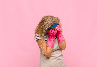 Orta yaşlı bir kadın üzgün, hayal kırıklığına uğramış, gergin ve depresif, iki eliyle yüzünü kapatan, ağlayan hizmetçi konsepti.