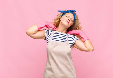 Orta yaşlı bir kadın stresli, endişeli, yorgun ve hayal kırıklığına uğramış, gömleğini çekmiş, sorunlu ev hanımı kavramından bıkmış görünüyor.