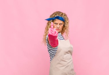 Orta yaşlı bir kadın kızgın, sinirli, asi ve agresif, orta parmağını sallayarak, hizmetçi kavramına karşı koyuyor.