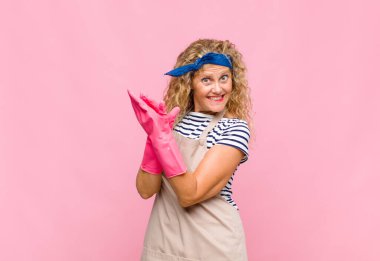 Orta yaşlı kadın kendini mutlu ve başarılı hissediyor, gülümsüyor ve el çırpıyor, alkışlayan hizmetçi konseptiyle tebrik ediyor.