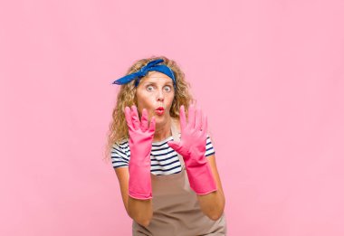 Orta yaşlı bir kadın gülümsüyor ve arkadaş canlısı görünüyor. 9 ya da 9 numarayı gösteriyor. Elleri önde, hizmetçi konseptini sayıyor.