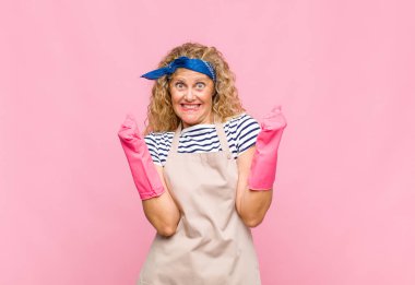 Orta yaşlı kadın son derece mutlu ve şaşırmış görünüyor, başarıyı kutluyor, bağırıyor ve zıplayan hizmetçi konsepti