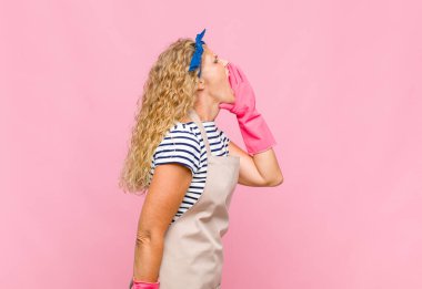 Orta yaşlı kadın profili, mutlu ve heyecanlı görünüyor, bağırıyor ve oda hizmetçisi kavramını kopyalamak için arıyor.