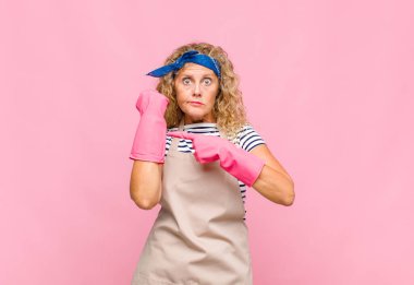 Orta yaşlı bir kadın sabırsız ve kızgın görünüyor, saati gösteriyor, dakiklik istiyor, zamanında hizmetçi konseptinde olmak istiyor.