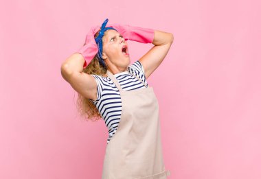 Ağzı açık orta yaşlı bir kadın, korkunç bir hata yüzünden dehşete düşmüş ve şok olmuş görünüyor, baş hizmetçi konseptine el kaldırıyor.