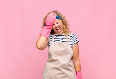 Orta yaşlı bir kadın gülüyor ve alnına şaplak atıyor. Unuttum ya da aptalca bir hata yaptım. Hizmetçi konsepti. 