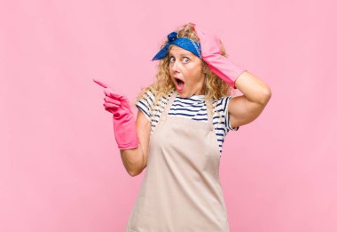 Orta yaşlı kadın gülüyor, mutlu, pozitif ve şaşırmış görünüyor. Yan fotokopi odası temizlikçisi kavramına işaret eden harika bir fikri fark ediyor.