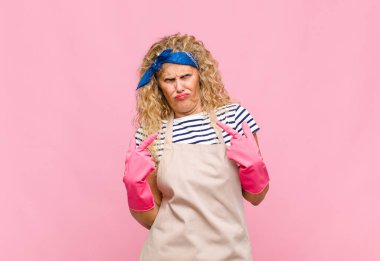 Kötü tavırlı orta yaşlı bir kadın gururlu ve agresif görünüyor, yukarı işaret ediyor ya da el temizlikçisi konseptiyle dalga geçiyor.