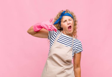 Orta yaşlı bir kadın mutsuz ve stresli görünüyor, intihar jesti silahla işaret yapıyor, baş hizmetçi kavramına işaret ediyor.