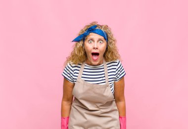 Orta yaşlı kadın korkmuş ve şok olmuş hissediyor, ağzı açık, sürpriz hizmetçi konseptinde.