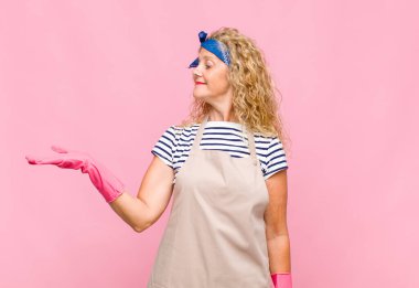 Orta yaşlı bir kadın kendini mutlu hissediyor ve gülümsüyor. Yan hizmetçi konseptinde duran bir nesneye ya da konsepte bakıyor.