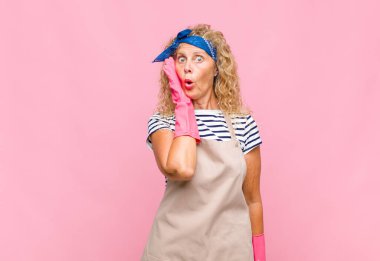 Orta yaşlı bir kadın, ağzı açık hizmetçi konseptiyle yüz yüze inanmayarak şok olmuş ve hayrete düşmüş hisseder.